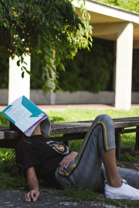 Woman with a book over her face